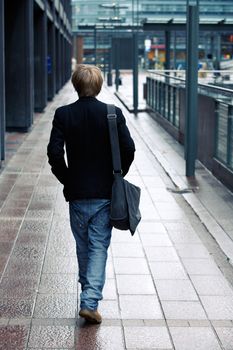 Teenage boy walking away from camera in street