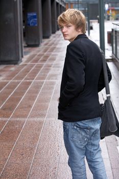 Teenage boy looking back over his shoulder in street