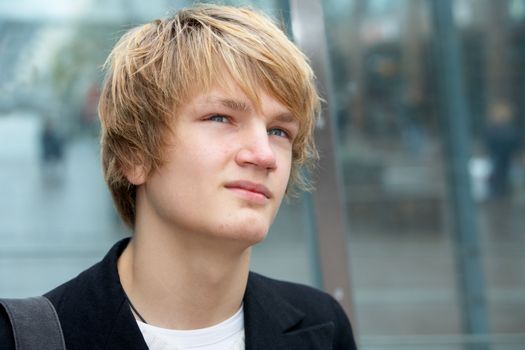 Portrait of teenage boy contemplating in urban environment