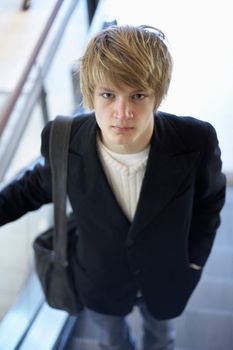 Interior shot of teenage boy standing in escalator