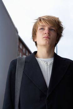 Portrait of teenage boy in street, low angle view