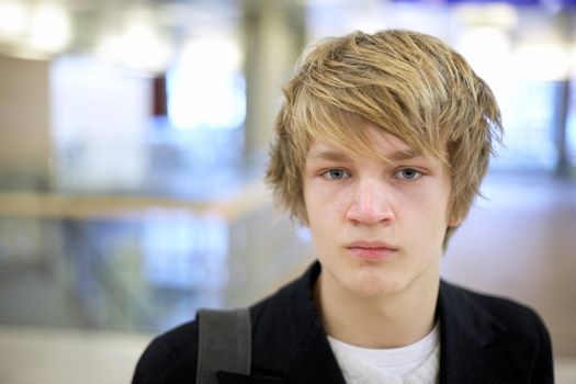 Portrait of teenager in modern building, looking at camera