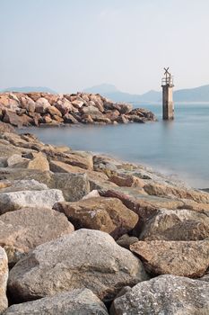 Lighthouse on a Rocky Breakwall: A small lighthouse warns of a rough shoreline. 