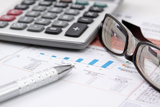 Stock chart with calculator,pen and eyeglasses 