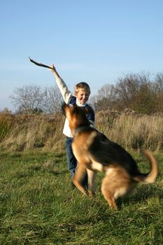 The little boy is training the big dog German Shepherd Dog ). The obedience and the cooperation.