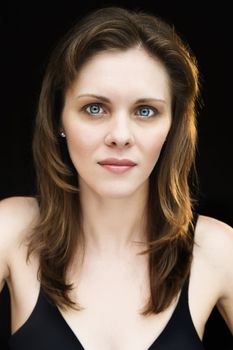 Head and shoulders portrait of serious young adult caucasian female.