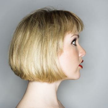 Profile portrait of young blonde caucasian woman who looks surprised.