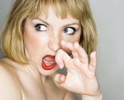 Portrait of young blonde caucasian woman who is looking off to the side with a disgusted expression.