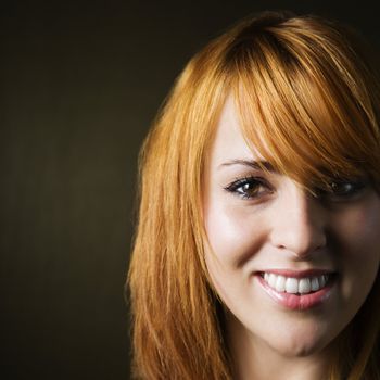 Close-up studio portrait of pretty young redheaded female.