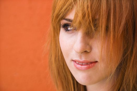 Close-up portrait of smiling young redheaded female looking mischievious.