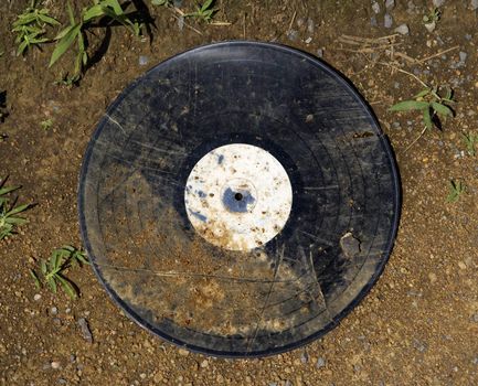 Dirty old record album on ground.