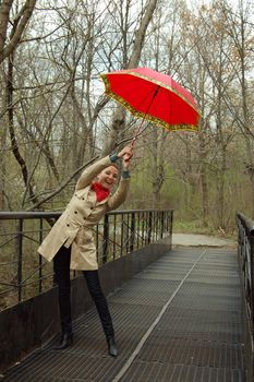 happy girl with red umbrella on bridge