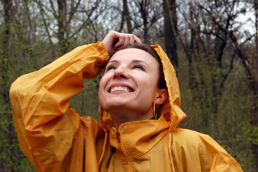 Happy girl in raincoat enjoying rain