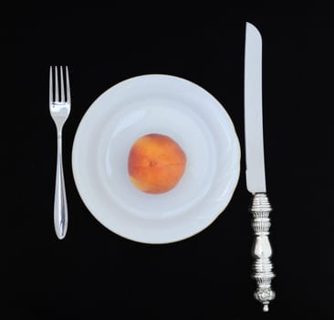 A Single Fresh Peach on White Plate and Knife 
and Fork. 