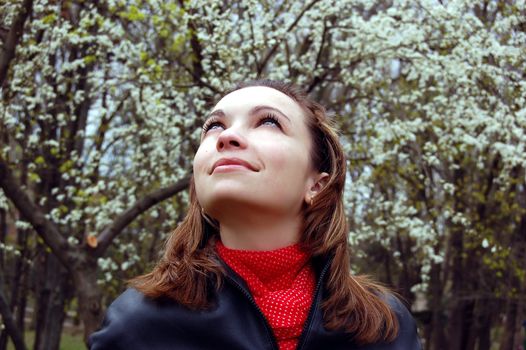 Girl looking up in blooming garden