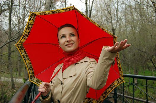 smiling girl in raincoat and red umbrella