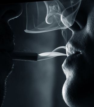 Two silhouettes of smoking people close-up