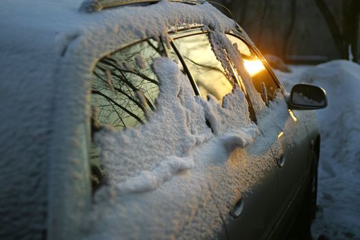 The automobile in snow on a sunset