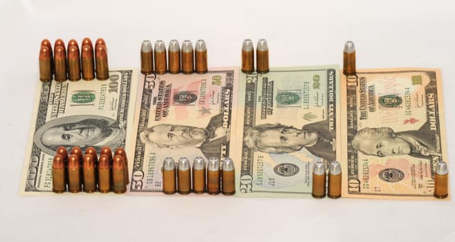 Handgun Cartridges on Background with 
 American  Dollar Bills.