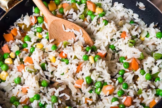 fried rice with vegetables in a skillet, close-up