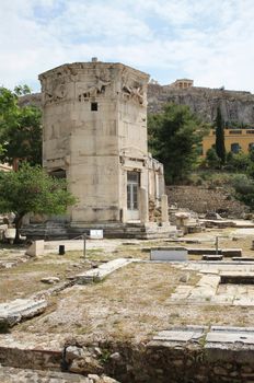 Tower of the Winds (Horologion or Aerides) in Athens, Greece. Built in 2nd century BC. It served as a compass, sundial, wetaher vane and water clock. Each face of the frieze is adorned with a relief of one of the god winds. Akropolis in the background. HDR.