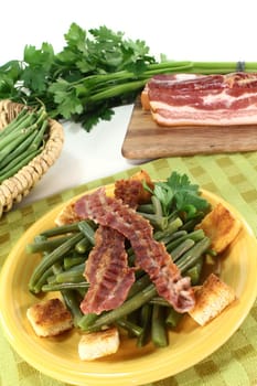 a plate of green beans and fried bacon