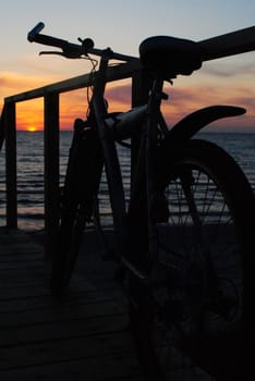 a lonely bicycle admiring the sunset on the beach