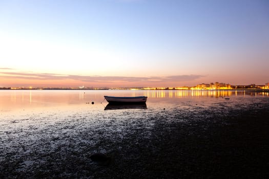 The city and the river with  small boat at sunset.