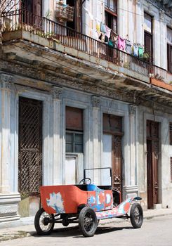 A colourful tattered open top 1912 vintage car in a street of Havana, Cuba.