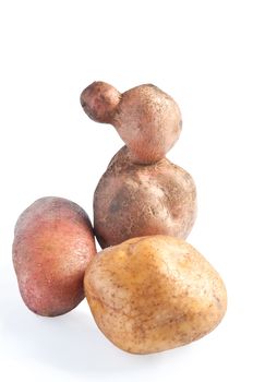 Three potatoes, one in the shape of a duck photographed against a white background