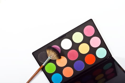 Make-up palette with brushes on white background. top view