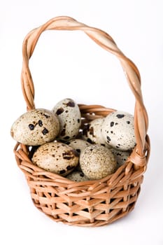 Quail eggs in basket isolated on a white background