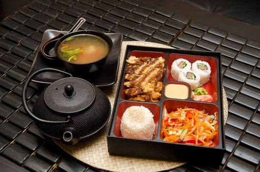 Sushi lunch with soup salad tea and sauce