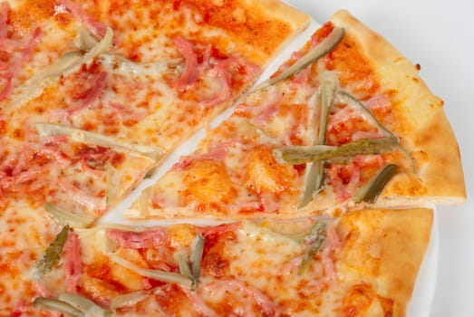 pizza closeup with boiled sausage, ham, marinated gherkin and mozzarella cheese