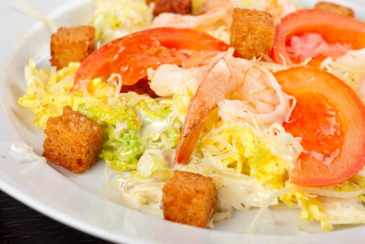 Salad of tiger shrimps, lettuce, chinese cabbage, tomato, garlic rusk, parmesan cheese and sauce