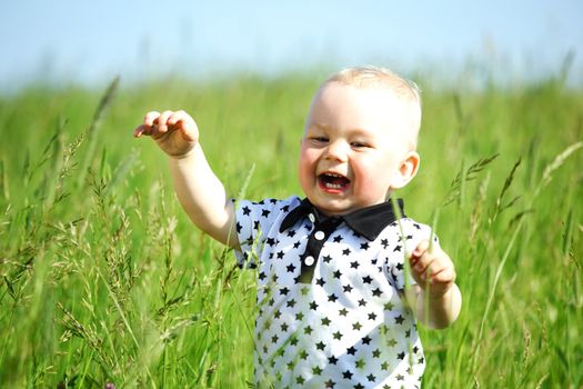 little boy play in green grass