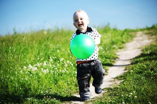  little boy play in green grass with green ball