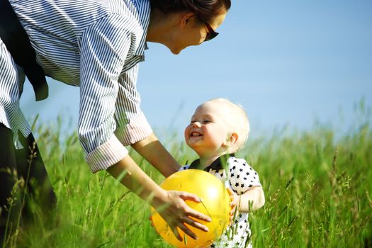  little boy play in green grass with yellow ball