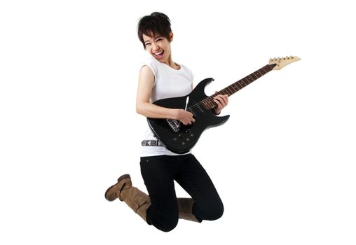 Asian female rockstar holding guitar jumping in air.