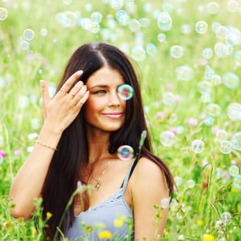  happy woman smile in green grass soap bubbles around