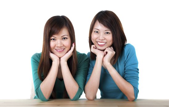 Two young adults sitting in front table smiling