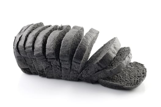 The cut loaf of black charcoal bread isolated on white