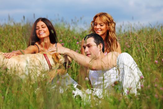 friends and dog in green grass field