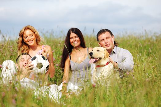 friends and dog in green grass field