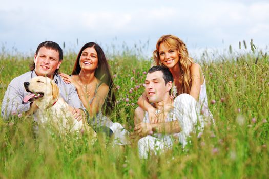 friends and dog in green grass field