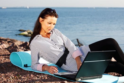 woman with laptop sea background