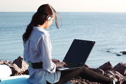 woman with laptop sea background