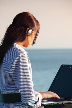 woman with laptop sea background