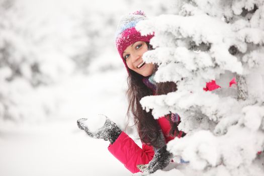 winter woman play snowballs on snow background