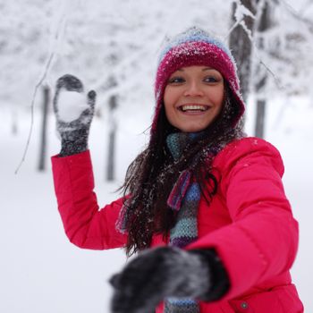 winter woman play snowballs on snow background